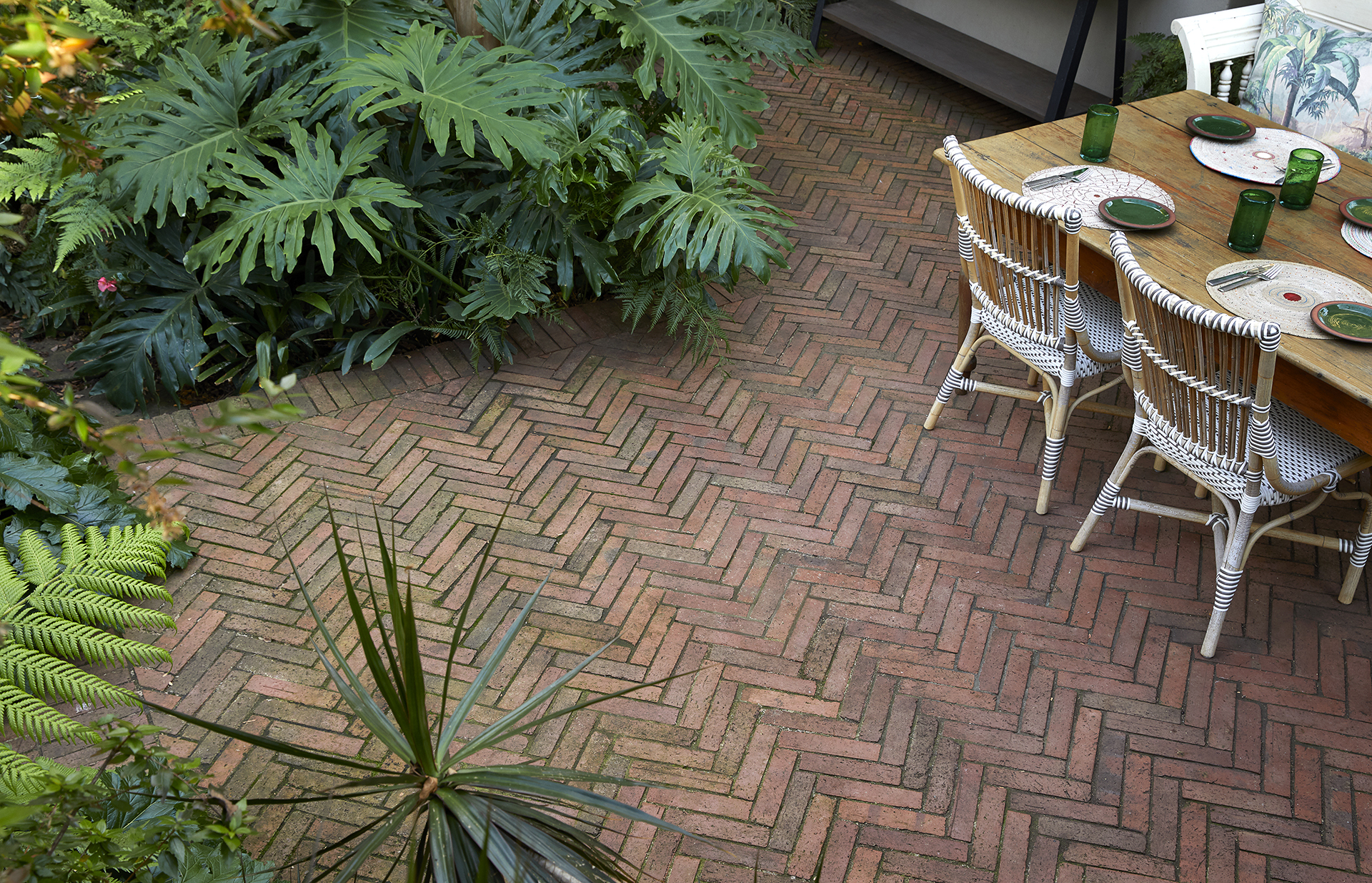 Brick herringbone-patterned patio floor by Young Garden Design